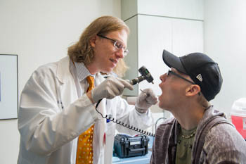 Nathaniel Treister, DMD, an oral expert with Dana-Farber/Brigham and Women's Cancer Center, checks a patient during an oral exam.