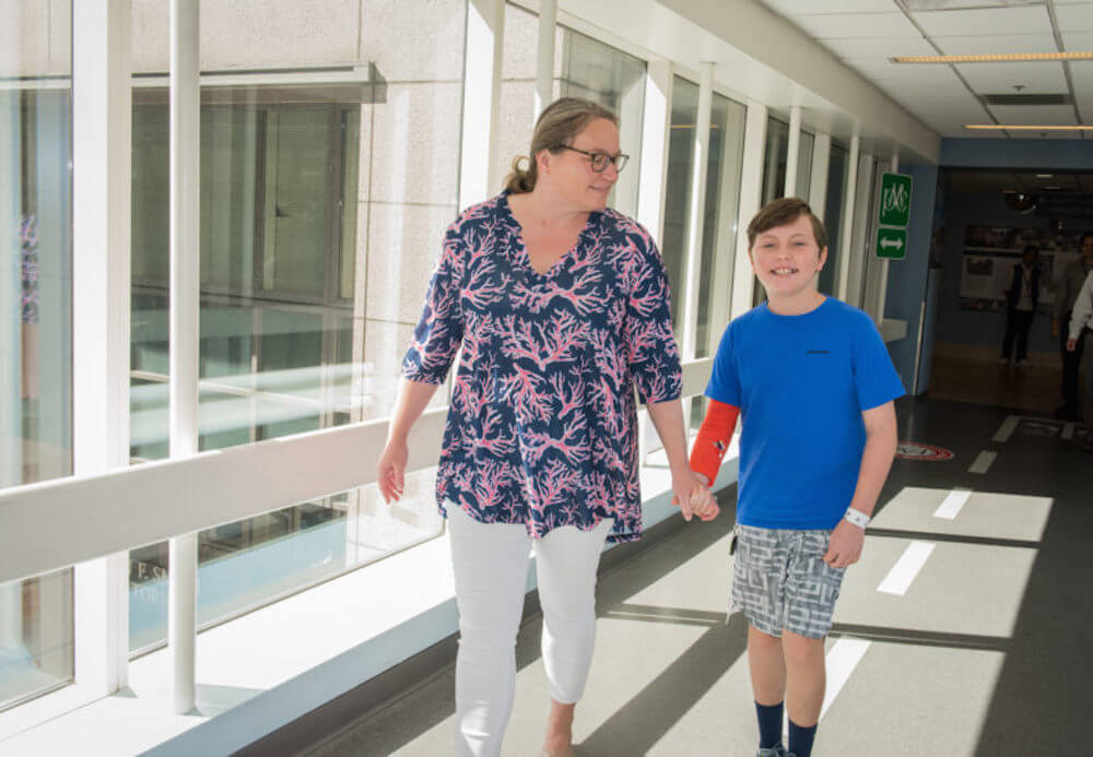 Eli and his mom walk through the hospital.