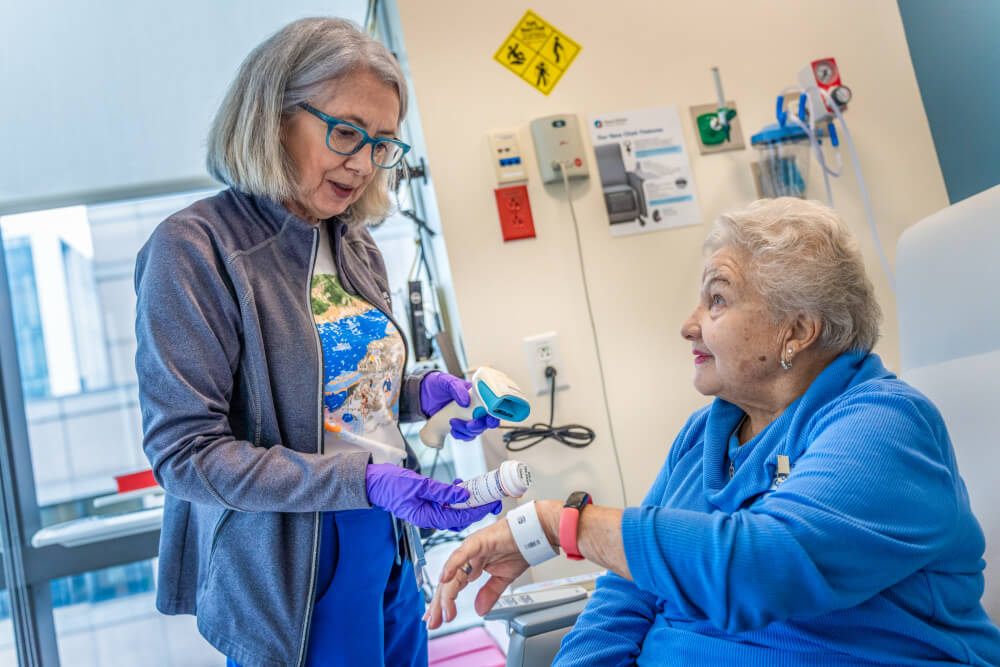 Mary McKenna, RN, a nurse in the CCTI, gives Camille Molloy her trial medicine. McKenna, originally from Ireland, also gave Camille inside information about the country when she and her family were preparing for their trip in 2022.  